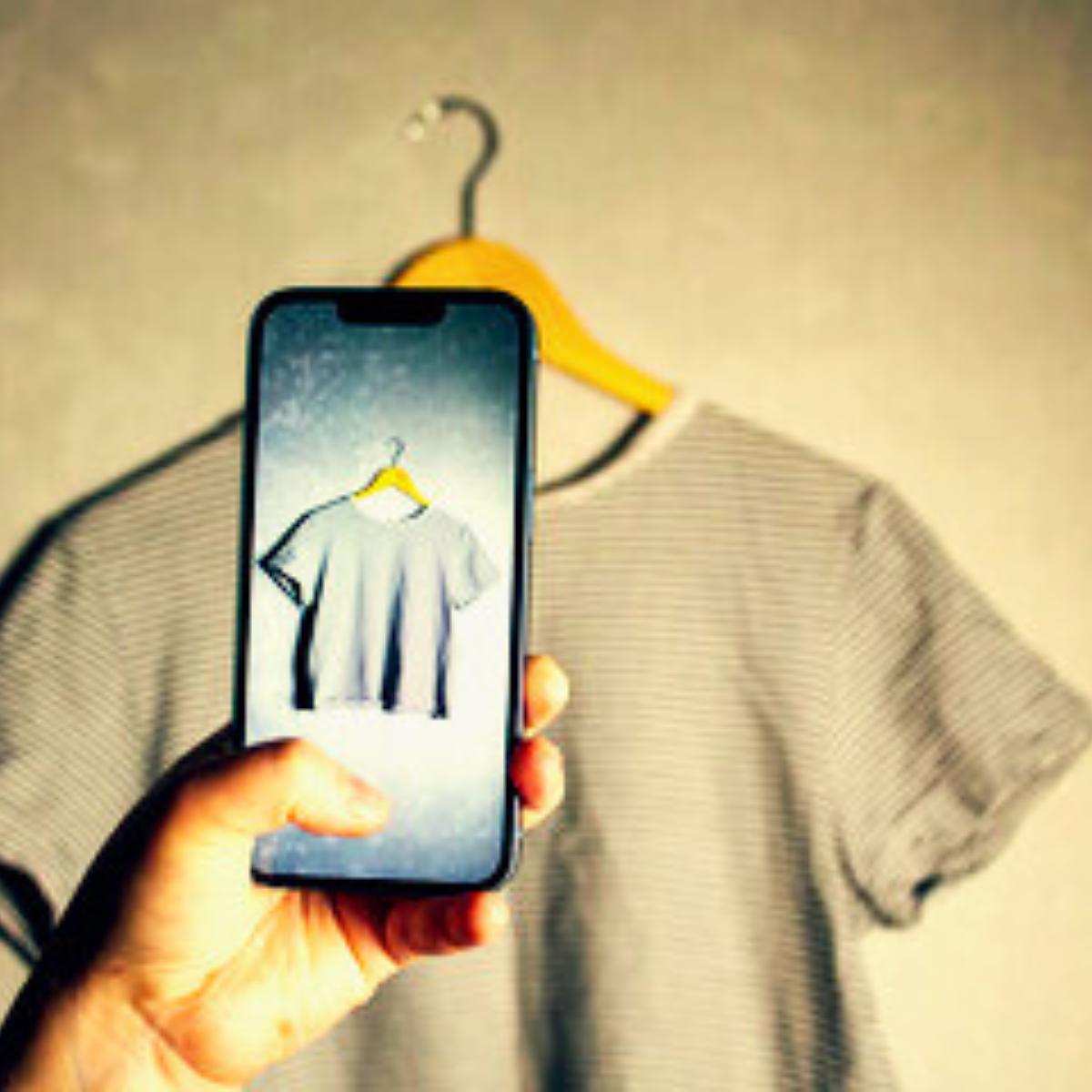 mano che fotografa una maglietta usata con smartphone